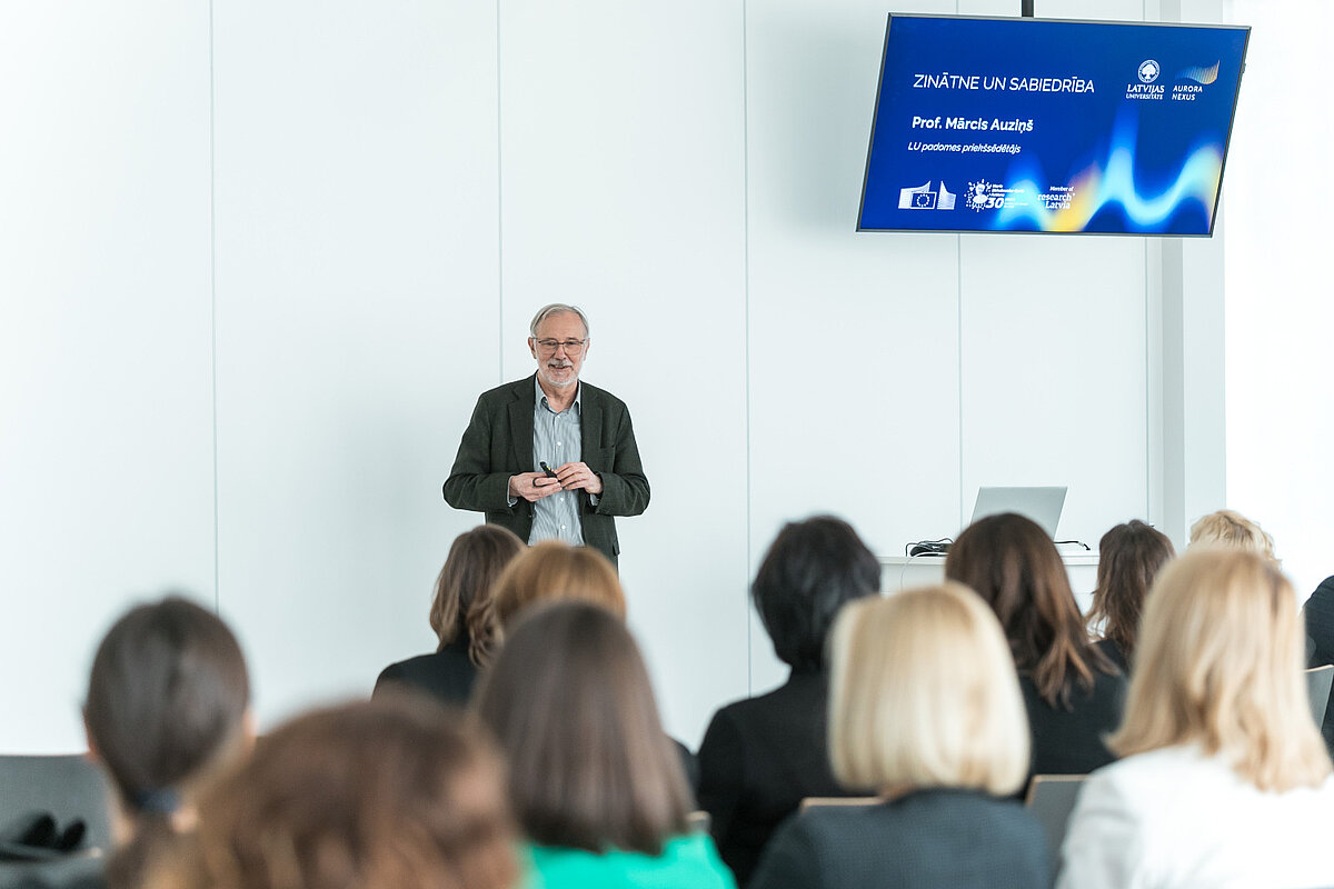 Projekta "Aurora Nexus"atklāšanas pasākums. Foto: Toms Grīnbergs, LU LU profesors Mārcis Auziņš, fonā prezentācija
