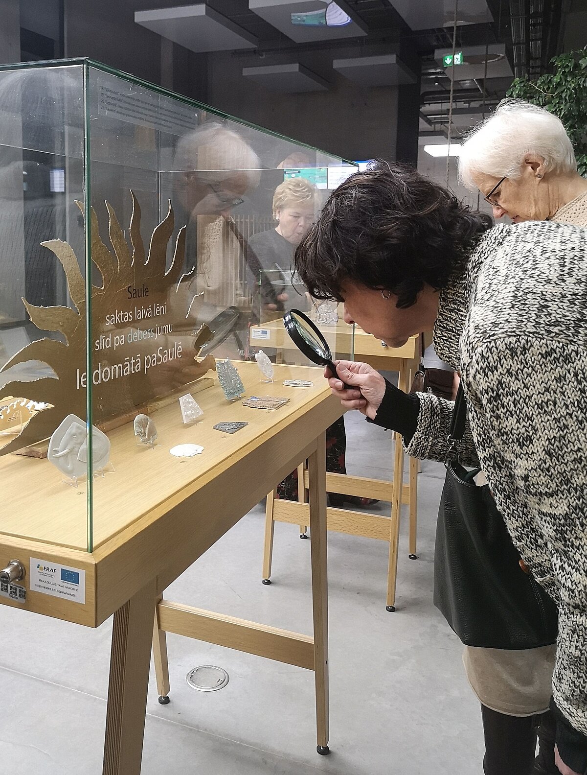 Izstādes atklāšanā miniatūros mākslas darbus varēja tuvāk aplūkot ar lupu.